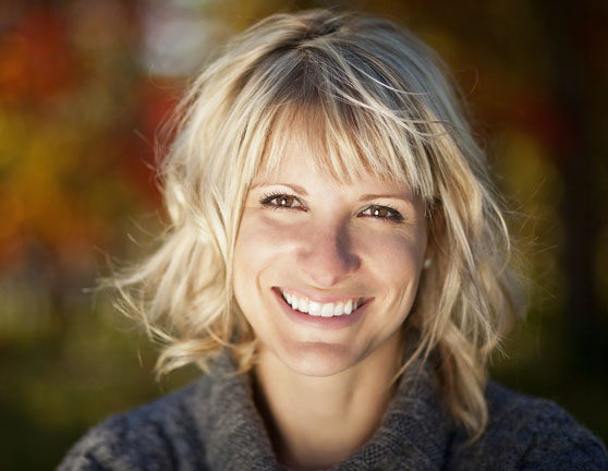 Mujer joven rubia con el pelo por los hombros sonriente mirando a la cámara
