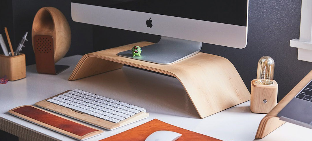 Escritorio con ordenador, altavoz, teclado y bolígrafos